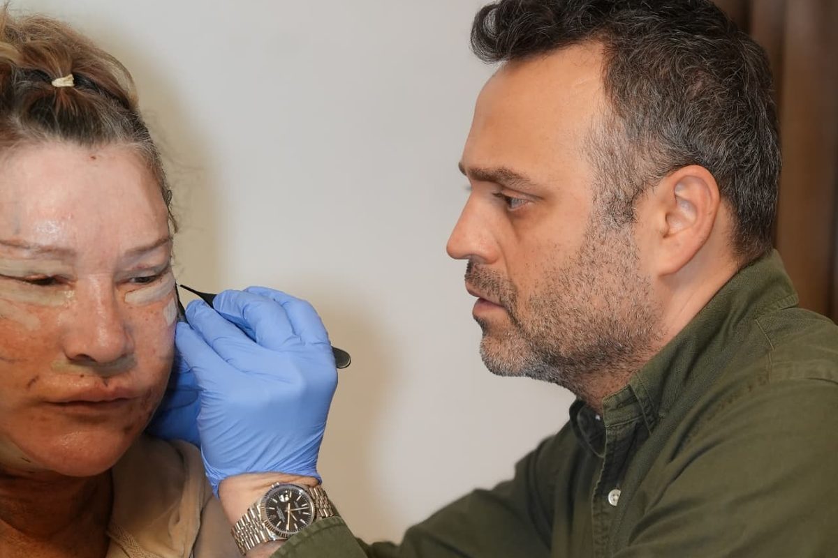 Surgeon examining a patient's incision line at a post-operative check in Istanbul